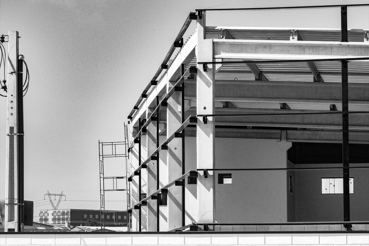 Black and white image of a modern building construction site with steel framework.